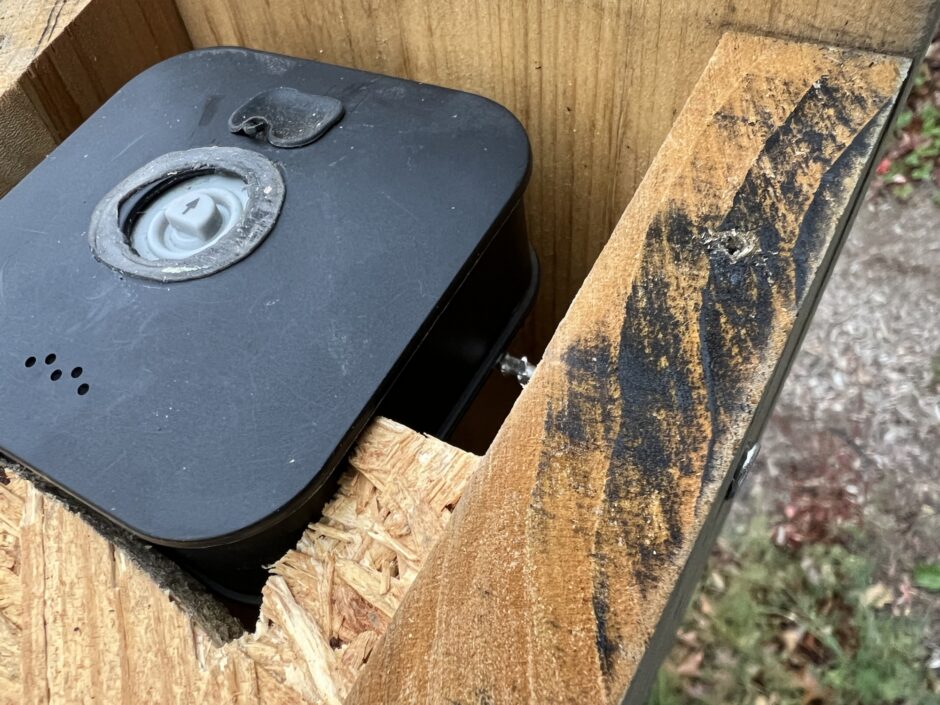 Blink camera sits on screws inside of the birdhouse